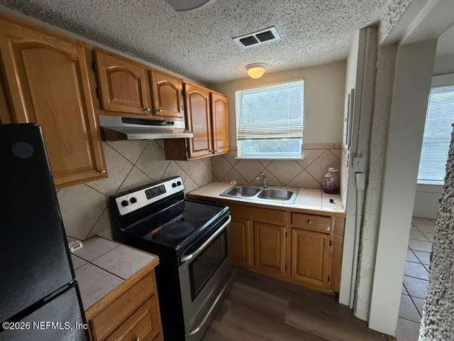 a kitchen with stainless steel appliances granite countertop a stove and a sink