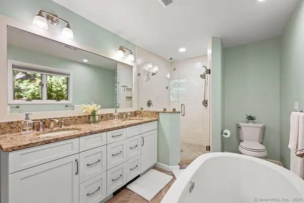 a spacious bathroom with a granite countertop sink mirror and a toilet