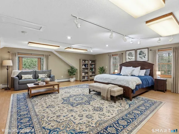 a spacious bedroom with a bed a couch and dresser