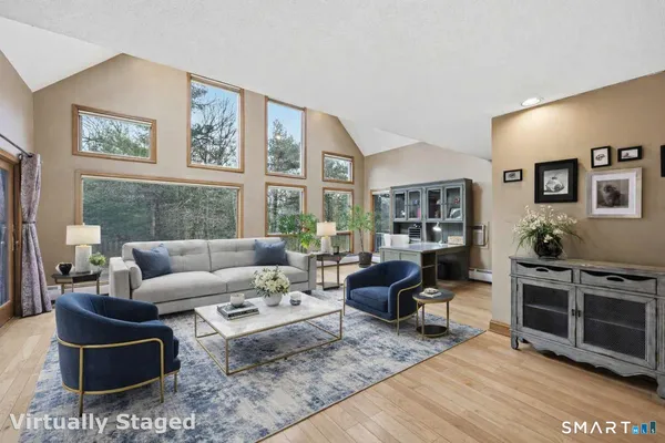 a living room with furniture a rug and a flat screen tv