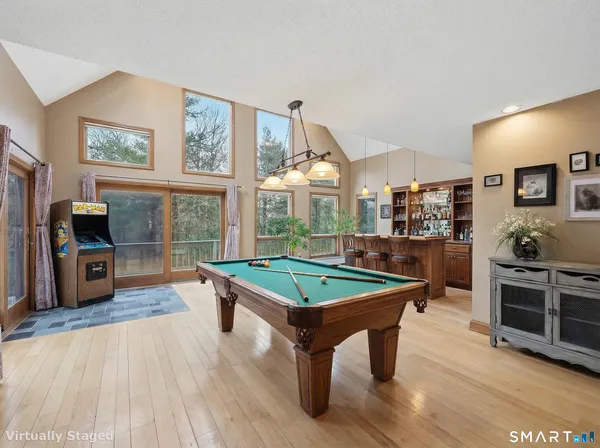 a room with furniture pool table flat screen tv and windows