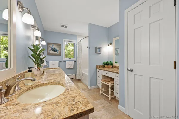 a en suite bathroom with a granite countertop sink and a mirror