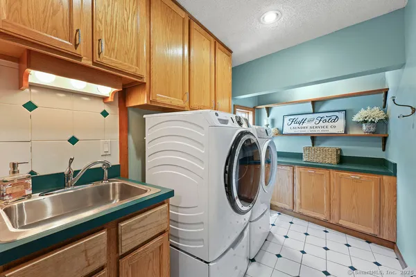 a utility room with stainless steel appliances lots of counter space and sink