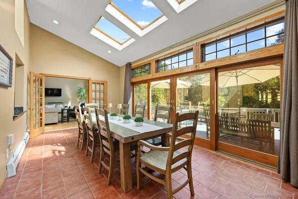 a dining room with furniture large windows and a rug