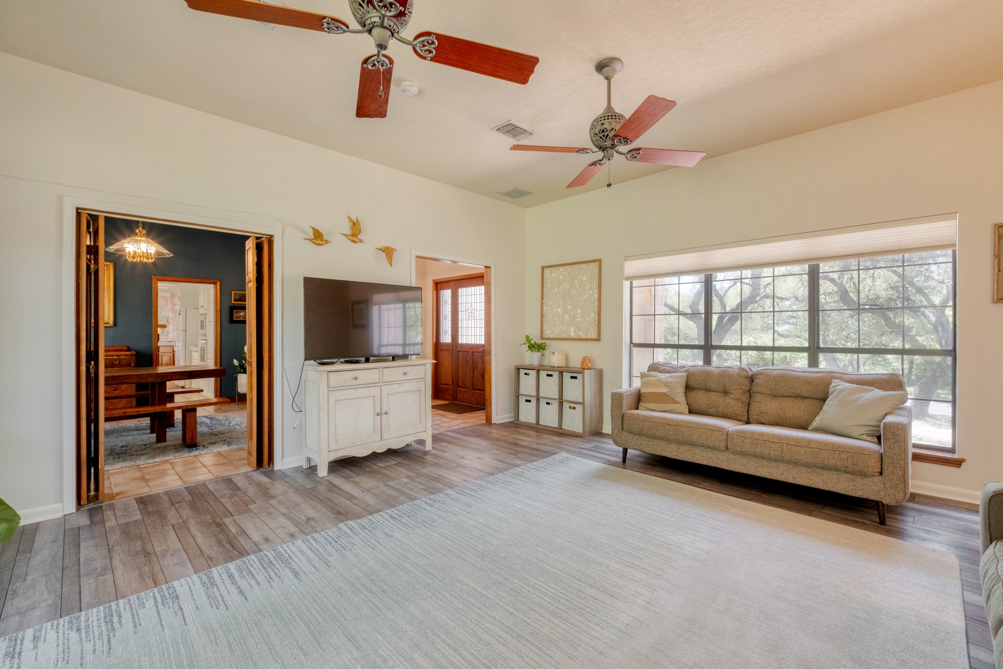 202 Ridgewood Drive Georgetown, TX 78628 - Photo 8 of 40 Spacious living area featuring wood-finish flooring, two ceiling fans, and a large window with exterior tree views