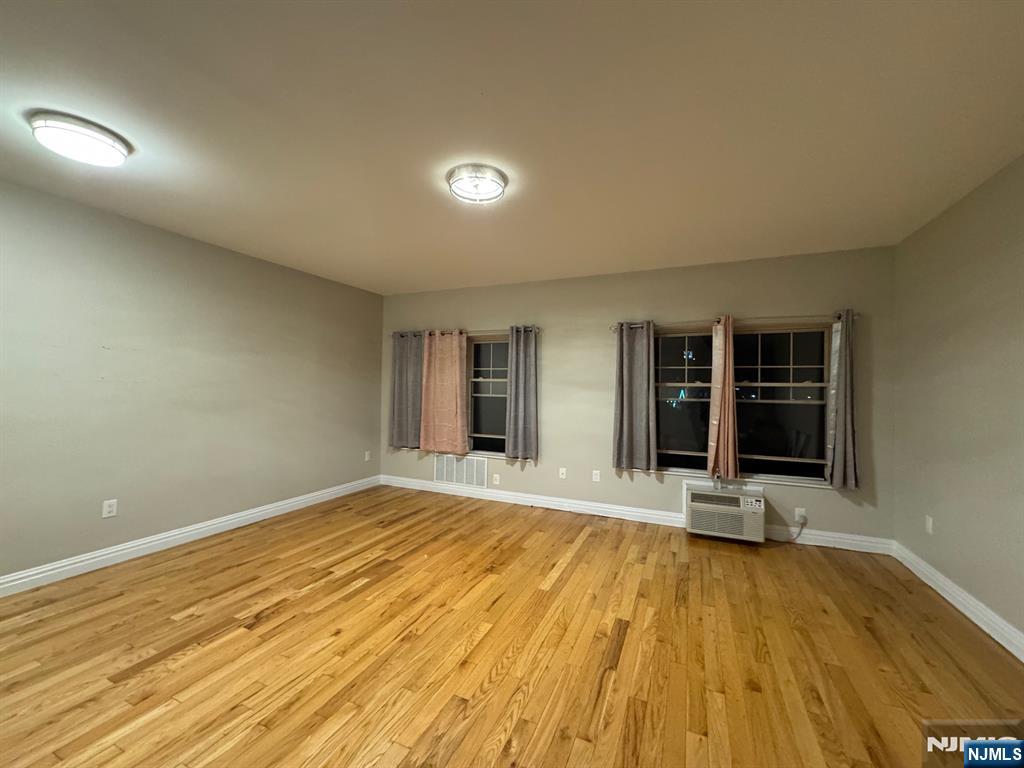 65 West Madison Avenue, Unit 4 Dumont, NJ 07628 - Photo 2 of 14 a view of an empty room with wooden floor and a window