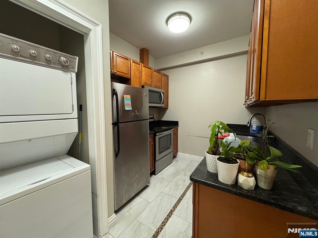 65 West Madison Avenue, Unit 4 Dumont, NJ 07628 - Photo 5 of 14 a kitchen with a refrigerator and washer