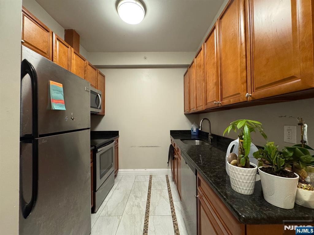 65 West Madison Avenue, Unit 4 Dumont, NJ 07628 - Photo 6 of 14 a kitchen with a refrigerator and a sink