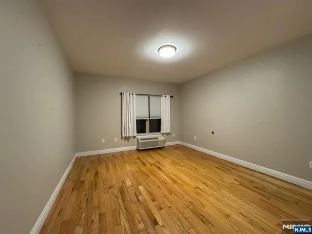 a view of a livingroom with wooden floor and a window