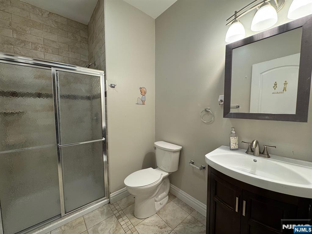 65 West Madison Avenue, Unit 4 Dumont, NJ 07628 - Photo 9 of 14 a bathroom with a toilet sink and shower