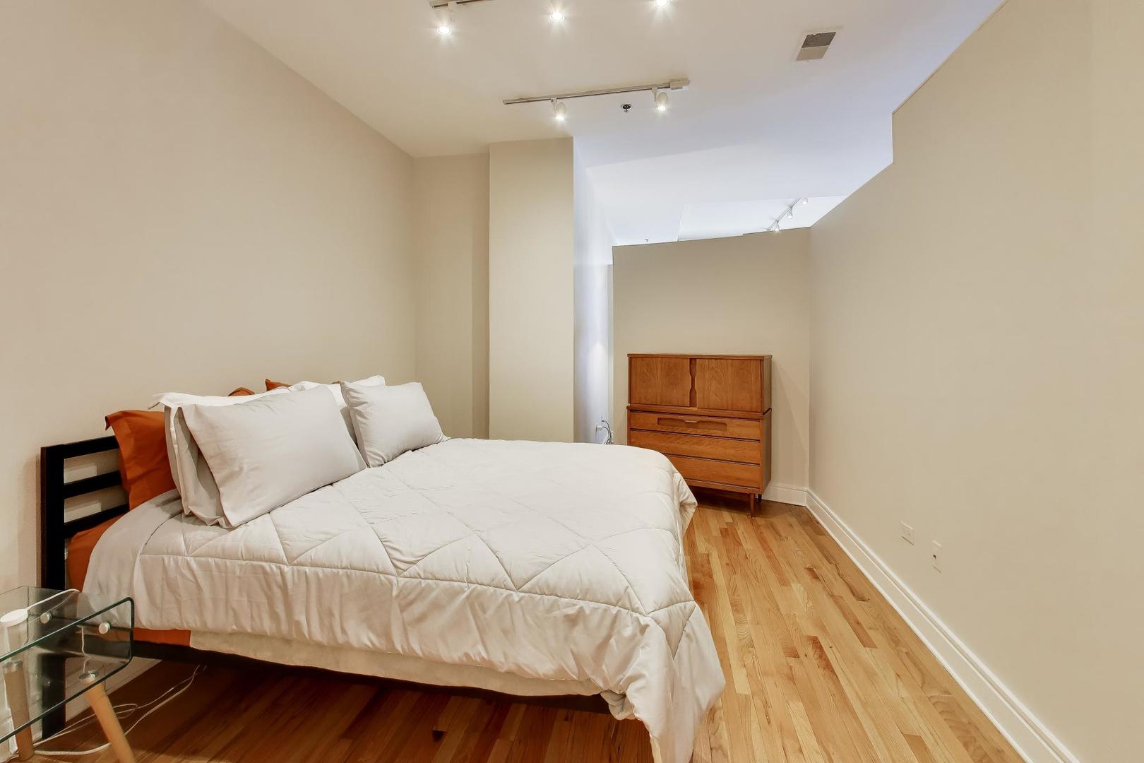 212 West Washington Street, Unit 908 Chicago, IL 60606 - Photo 13 of 32 a bedroom with a bed and a night stand