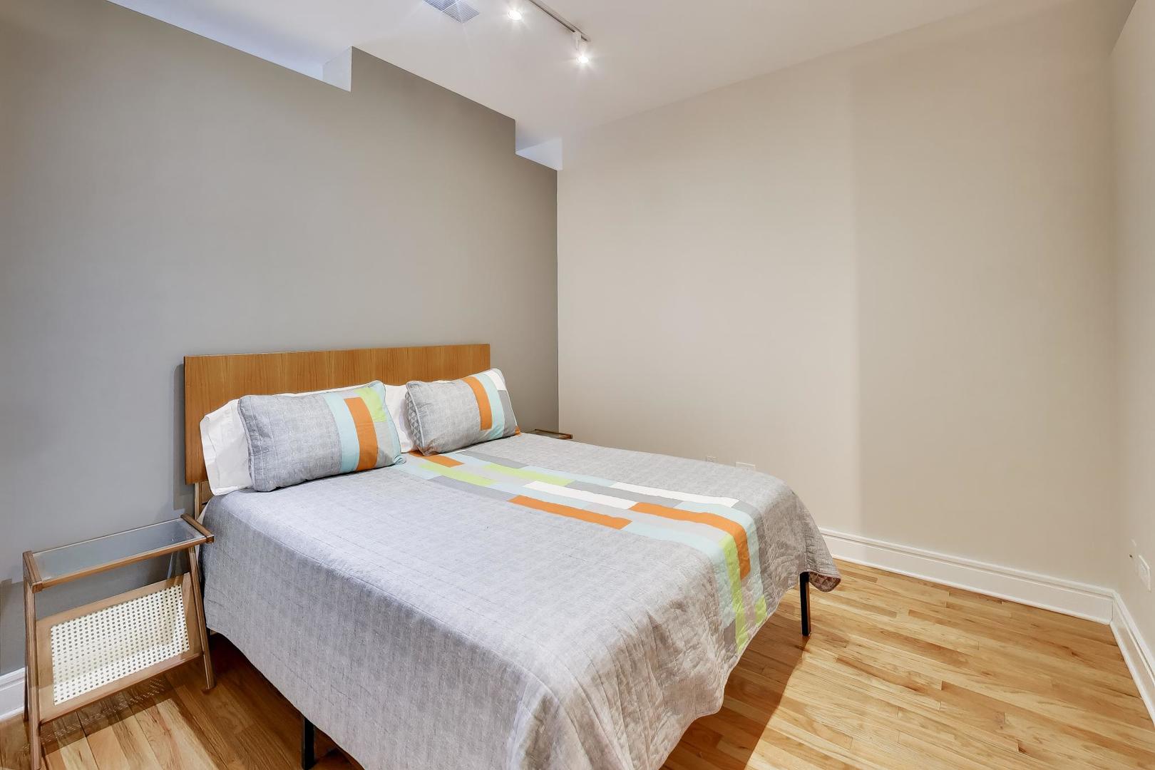 212 West Washington Street, Unit 908 Chicago, IL 60606 - Photo 18 of 32 a bedroom with a bed and wooden floor