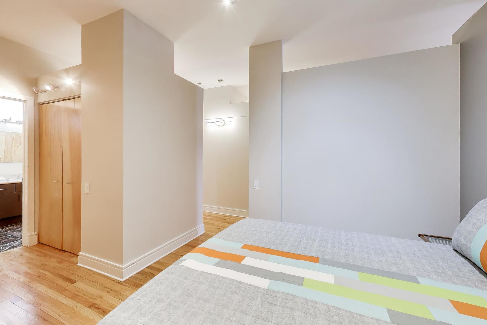 212 West Washington Street, Unit 908 Chicago, IL 60606 - Photo 19 of 32 a bedroom with a bed and a table in it