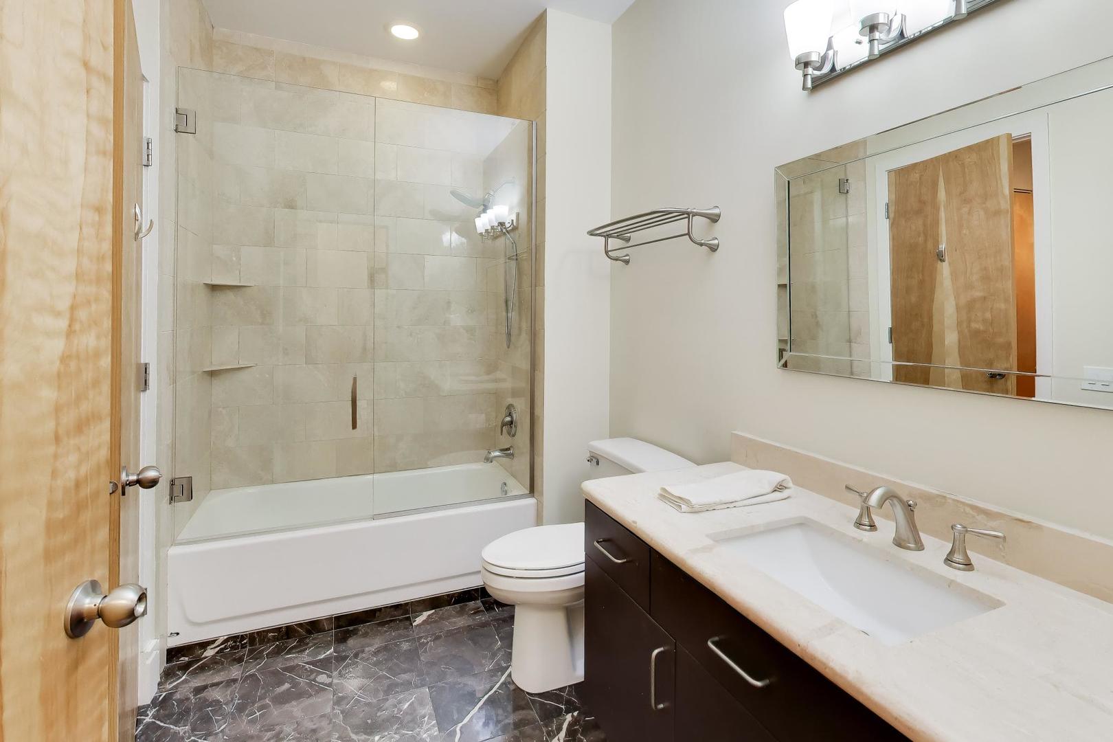 212 West Washington Street, Unit 908 Chicago, IL 60606 - Photo 20 of 32 a bathroom with a double vanity sink toilet mirror and bathtub