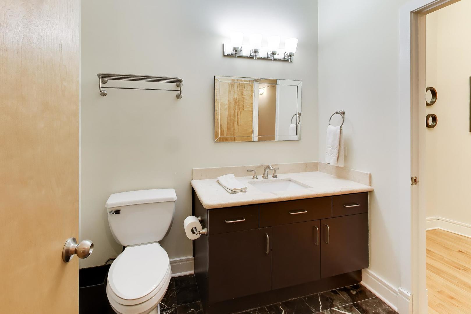 212 West Washington Street, Unit 908 Chicago, IL 60606 - Photo 21 of 32 a bathroom with a toilet sink and mirror
