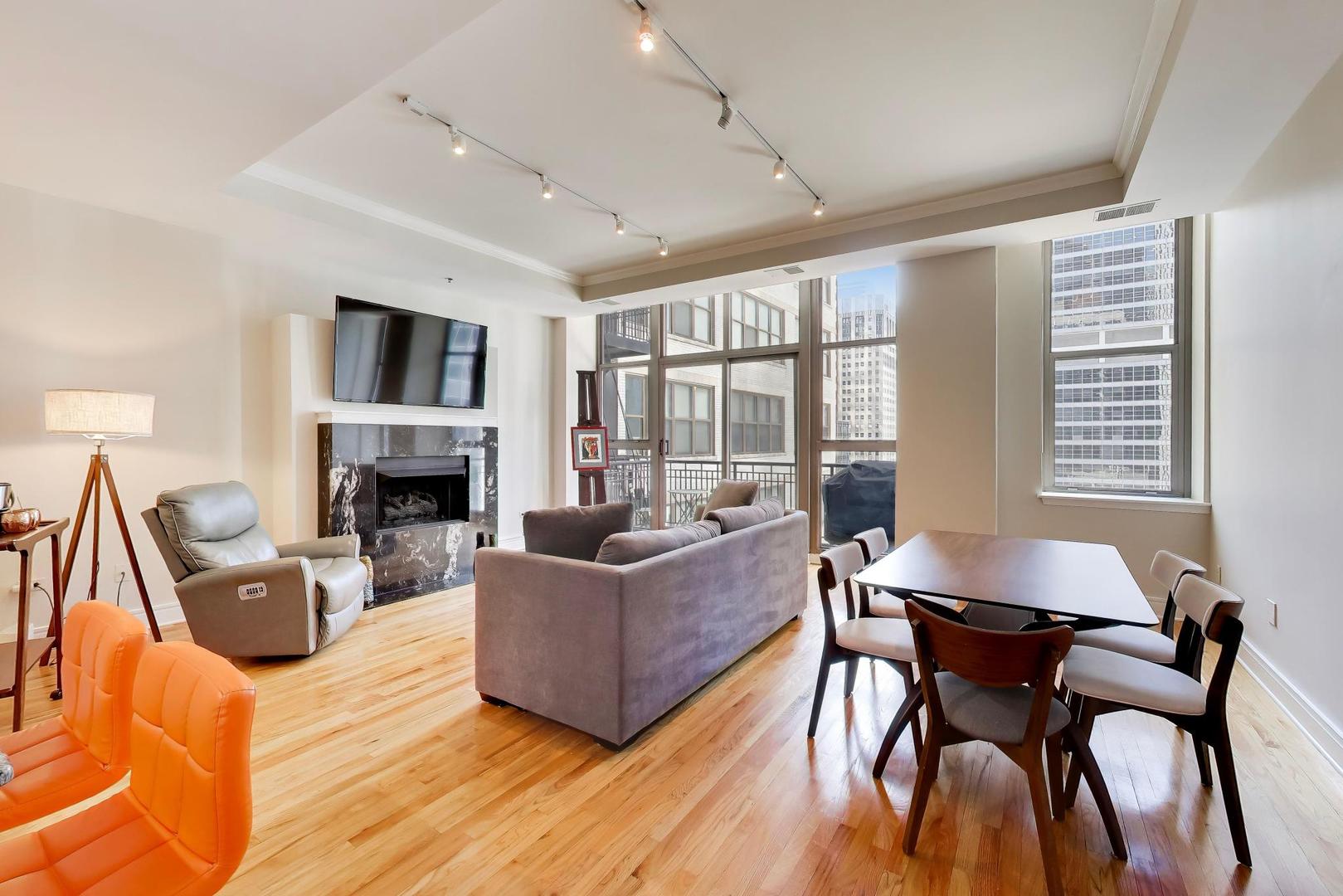 212 West Washington Street, Unit 908 Chicago, IL 60606 - Photo 3 of 32 a living room with furniture a fireplace and a large window
