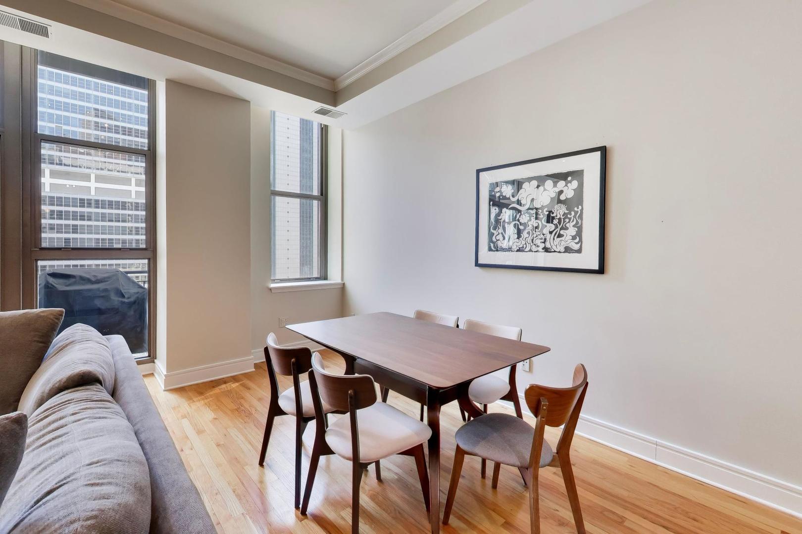 212 West Washington Street, Unit 908 Chicago, IL 60606 - Photo 8 of 32 a view of a dining room with furniture and wooden floor