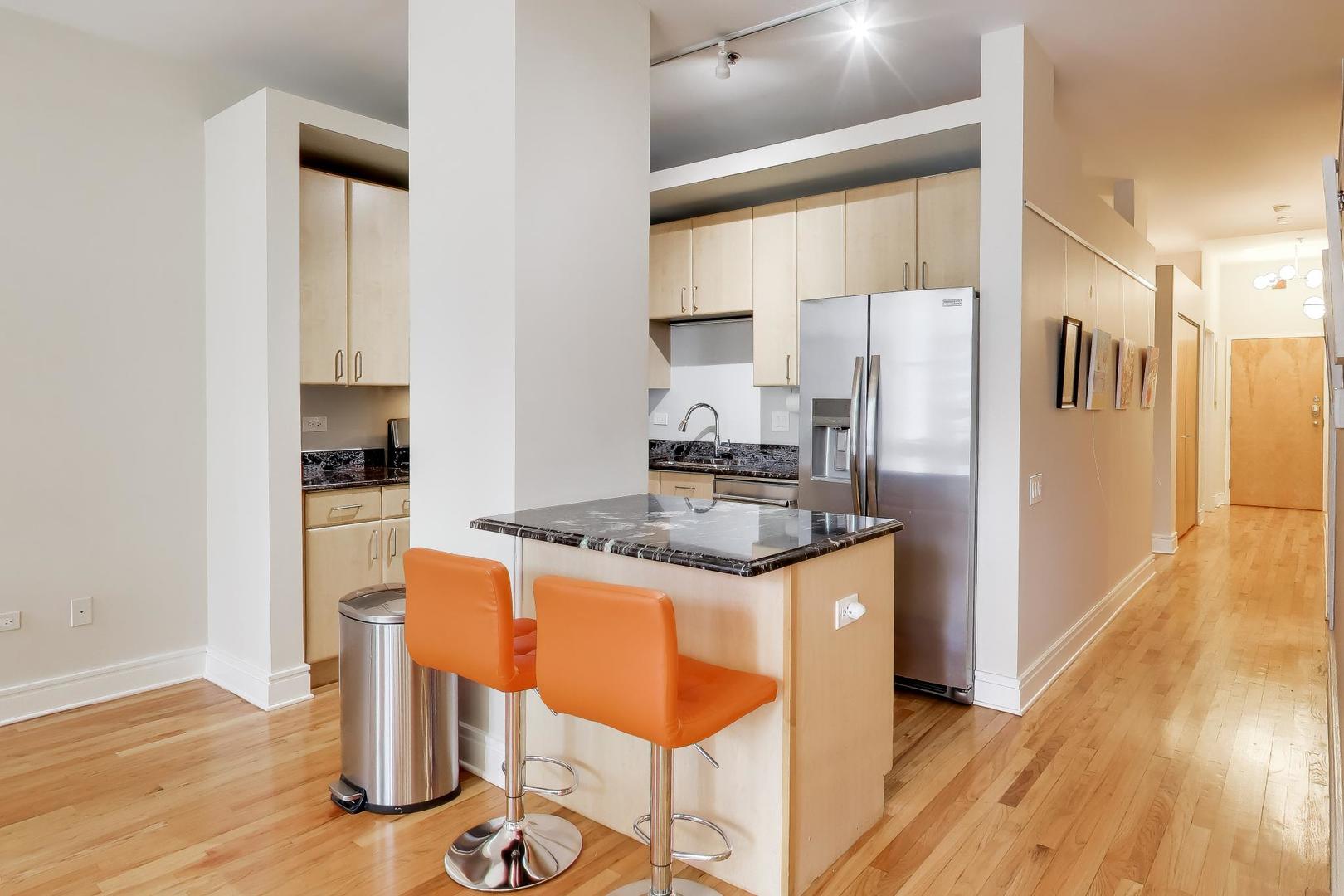 212 West Washington Street, Unit 908 Chicago, IL 60606 - Photo 9 of 32 a kitchen with granite countertop a refrigerator and a stove top oven