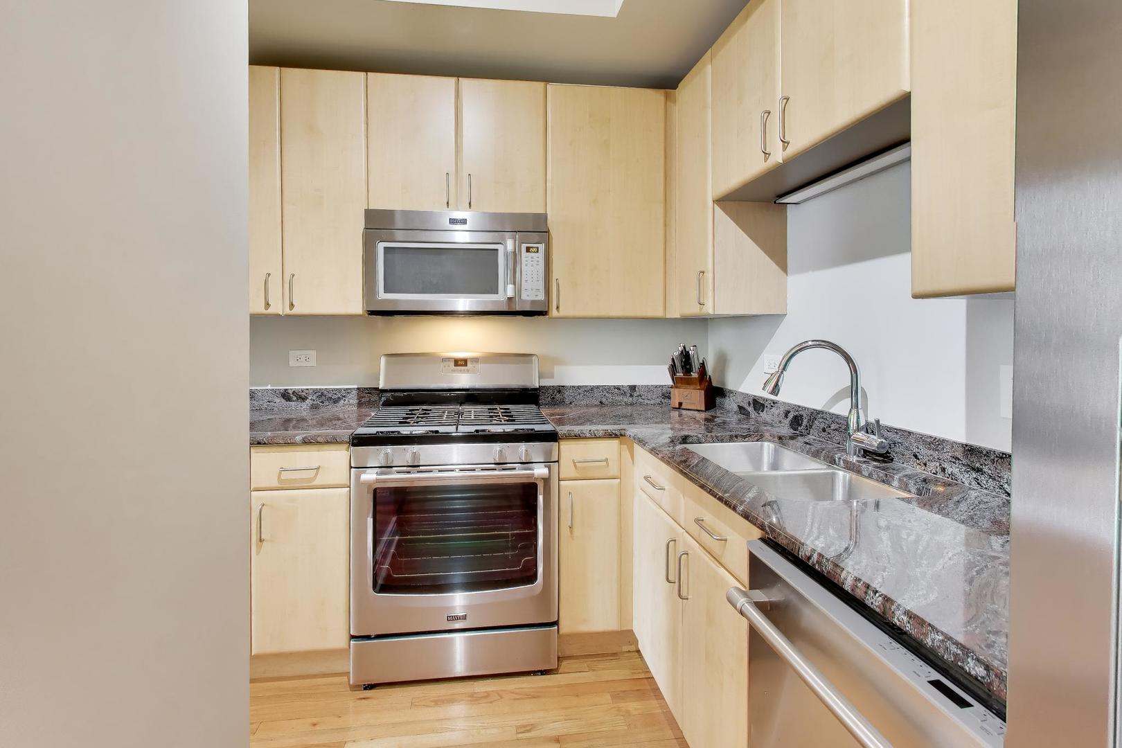 212 West Washington Street, Unit 908 Chicago, IL 60606 - Photo 10 of 32 a kitchen with stainless steel appliances granite countertop a stove and a sink