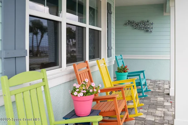 a view of a deck with a large window and palm tree