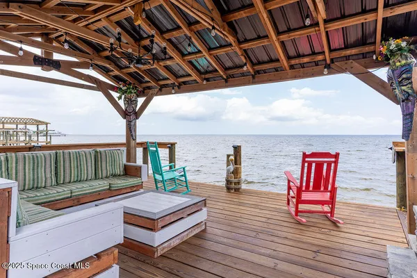 a view of roof deck with large trees and wooden stairs