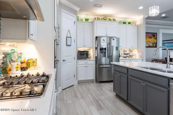 a kitchen with stainless steel appliances a stove a refrigerator and a sink with wooden floor
