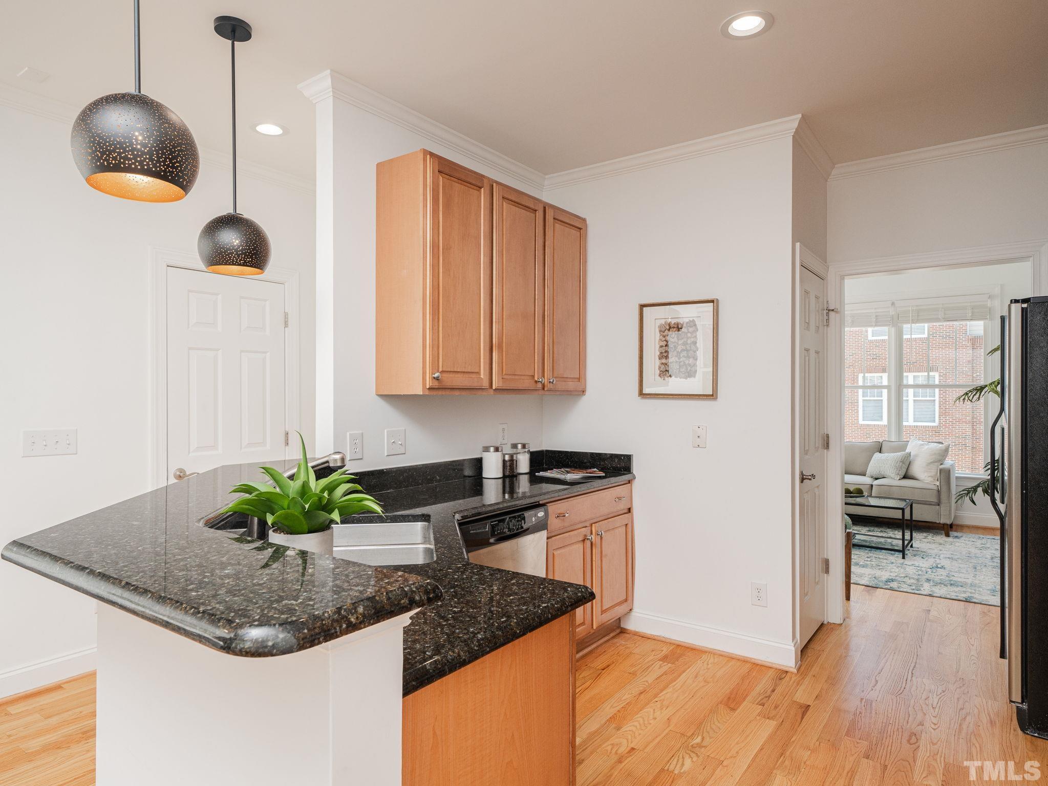 6109 Shandwick Court Raleigh, NC 27609 - Photo 14 of 36 a kitchen with stainless steel appliances granite countertop a sink a stove and a wooden floors