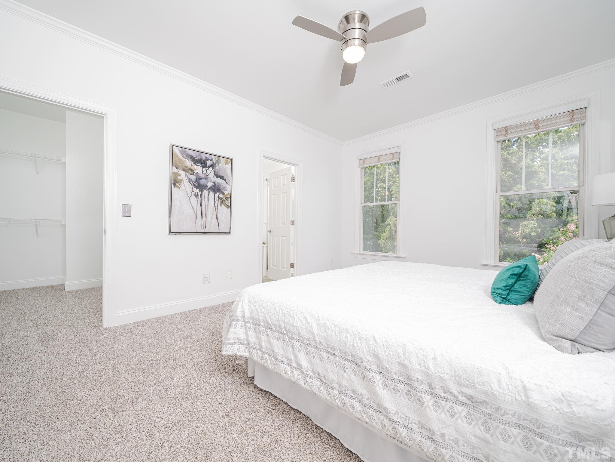 6109 Shandwick Court Raleigh, NC 27609 - Photo 26 of 36 a bedroom with a large bed and a chandelier