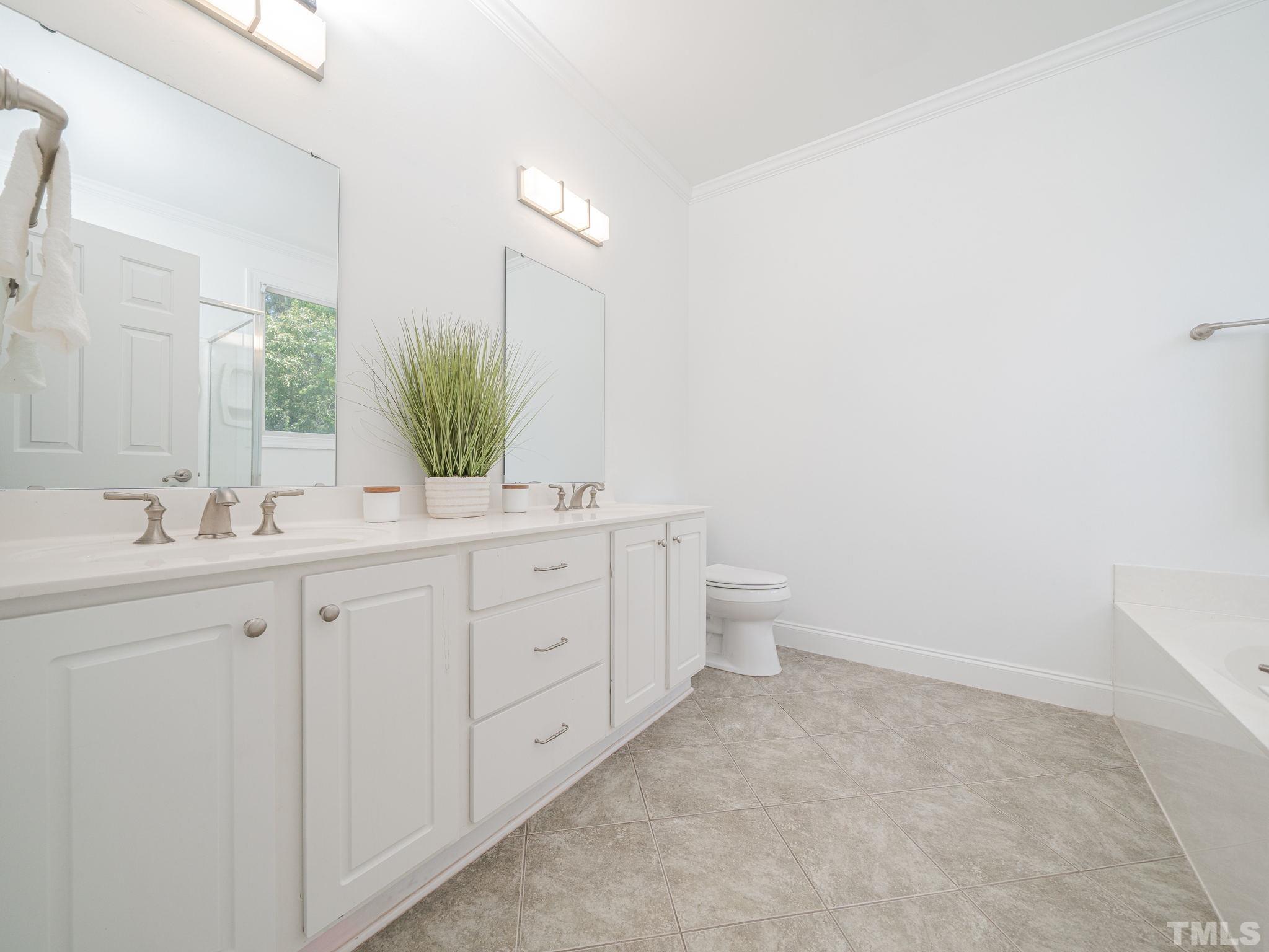 6109 Shandwick Court Raleigh, NC 27609 - Photo 28 of 36 a bathroom with a double vanity sink and a mirror