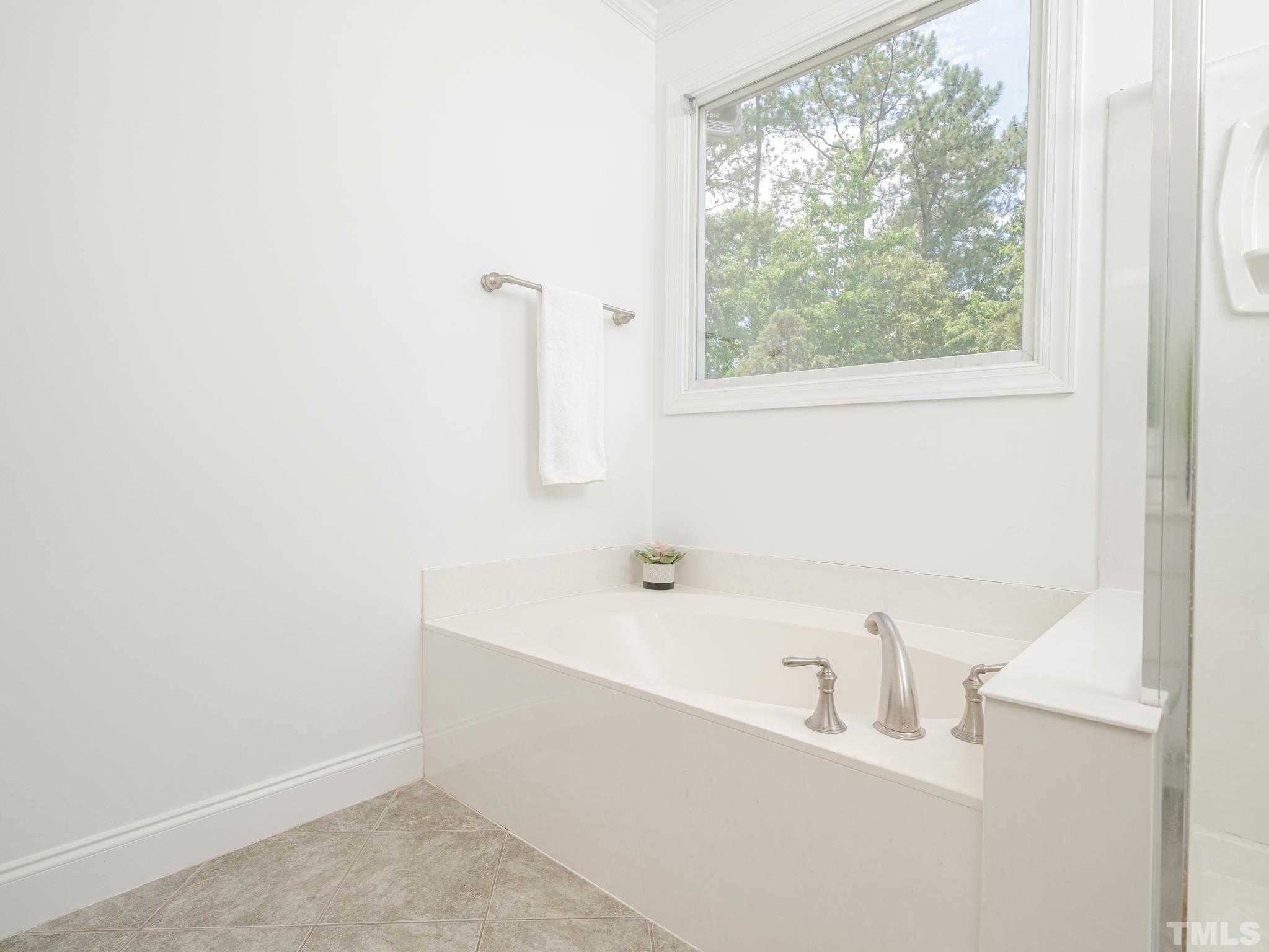 6109 Shandwick Court Raleigh, NC 27609 - Photo 29 of 36 a bathroom with a bathtub and a window
