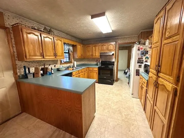 a kitchen with stainless steel appliances granite countertop a refrigerator a stove top oven a sink and dishwasher