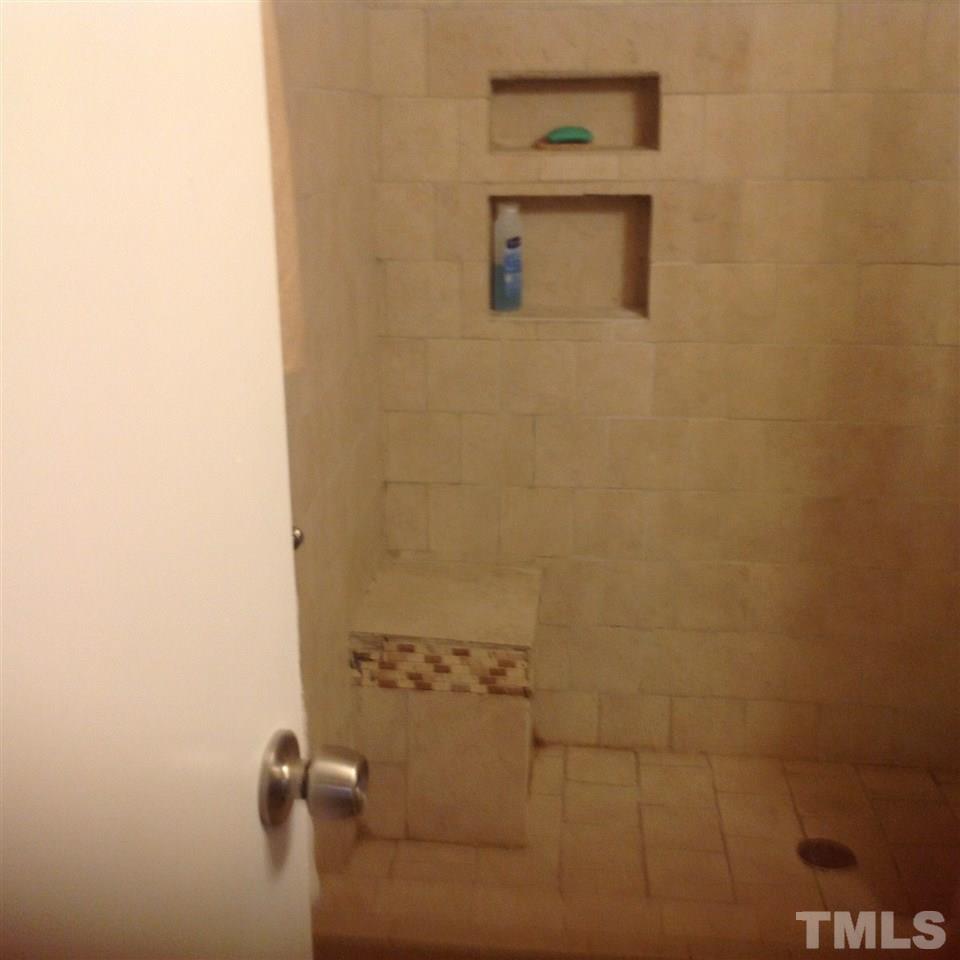 beautiful tile shower in master with sitting area