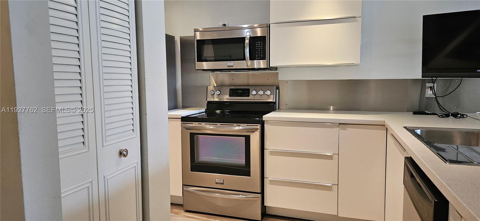 9450 Poinciana Place, Unit 103 Davie, FL 33324 - Photo 12 of 30 a kitchen with a stove and a microwave