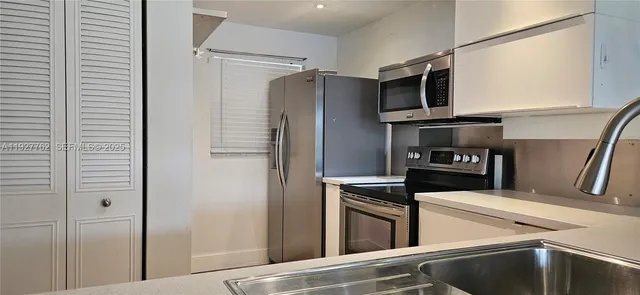 a kitchen with stainless steel appliances and refrigerator