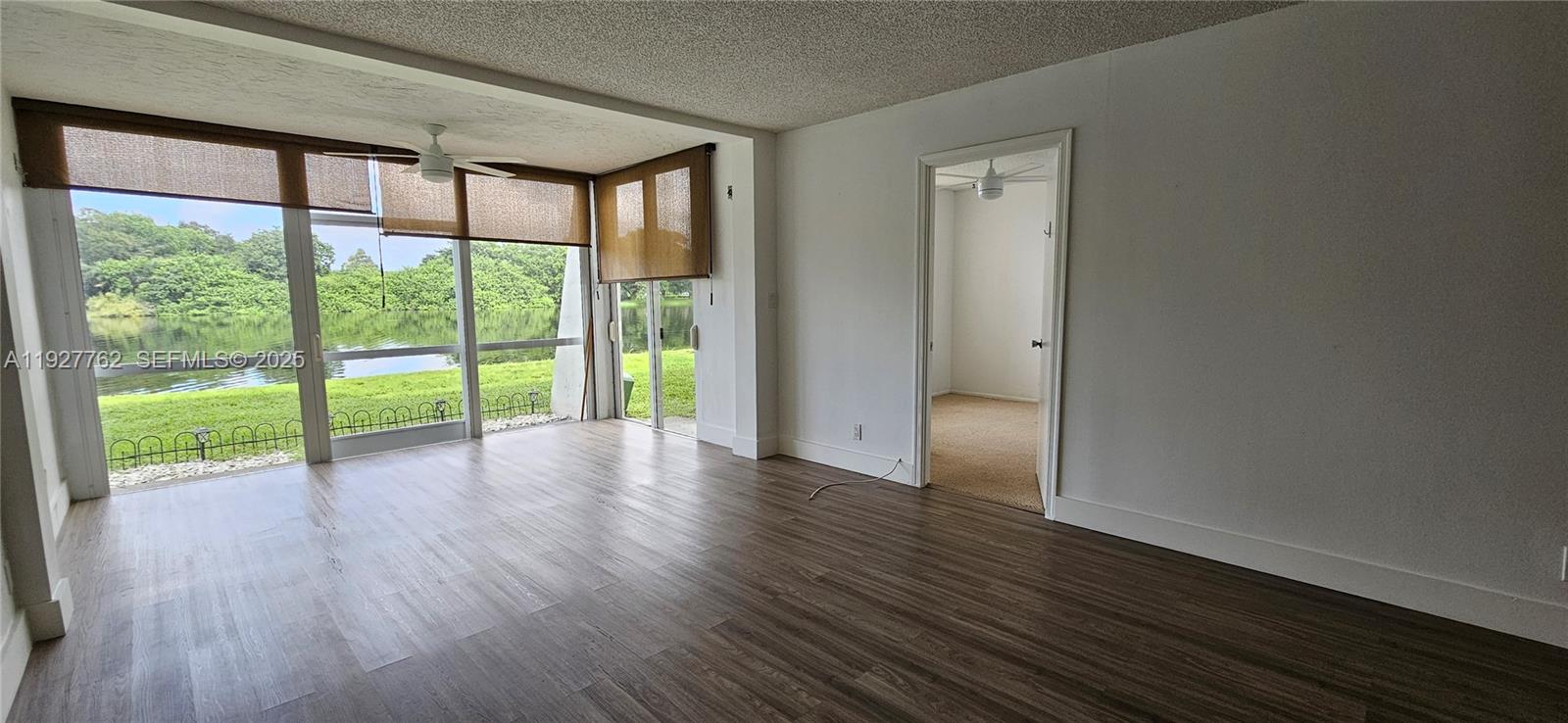 9450 Poinciana Place, Unit 103 Davie, FL 33324 - Photo 17 of 30 a view of an empty room with wooden floor and a window