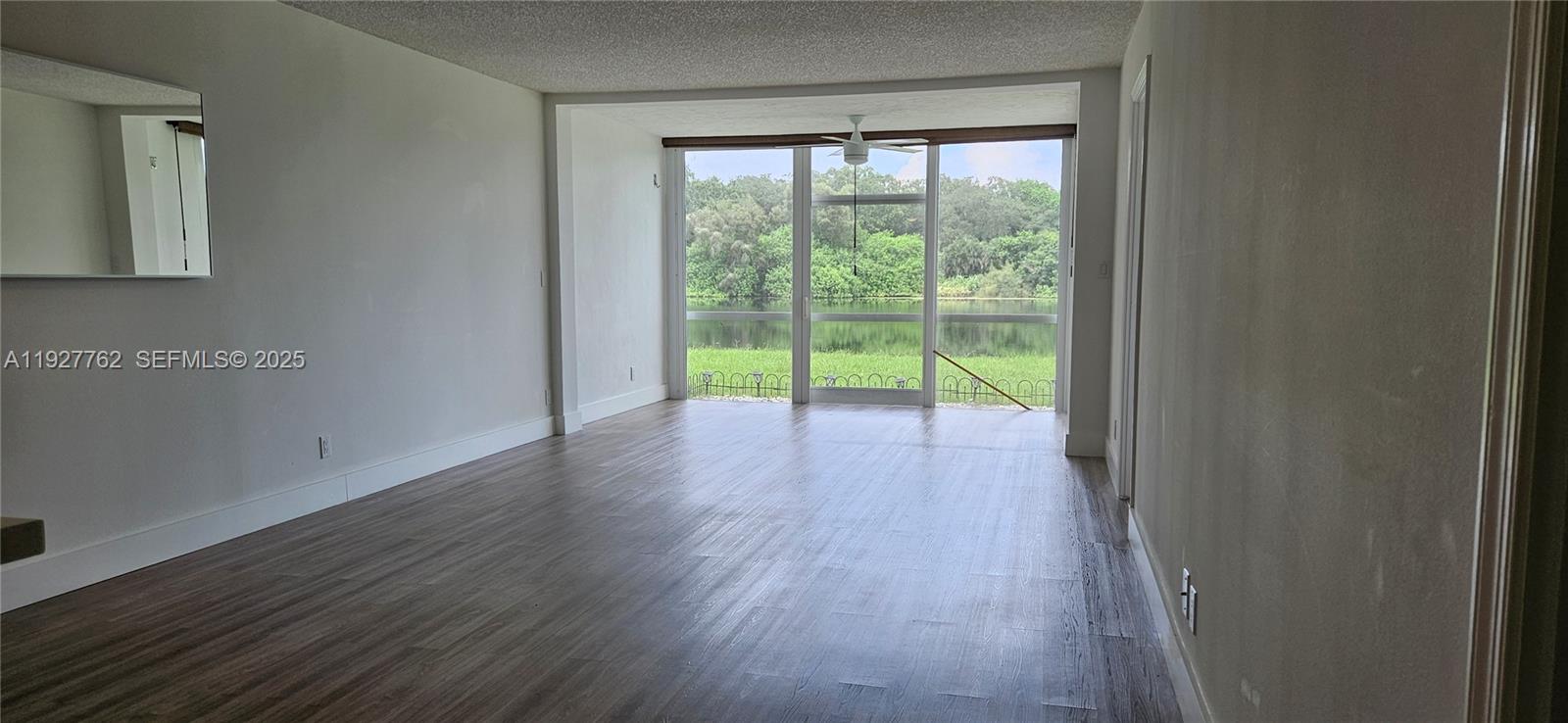 9450 Poinciana Place, Unit 103 Davie, FL 33324 - Photo 2 of 30 a view of an empty room with wooden floor and a window