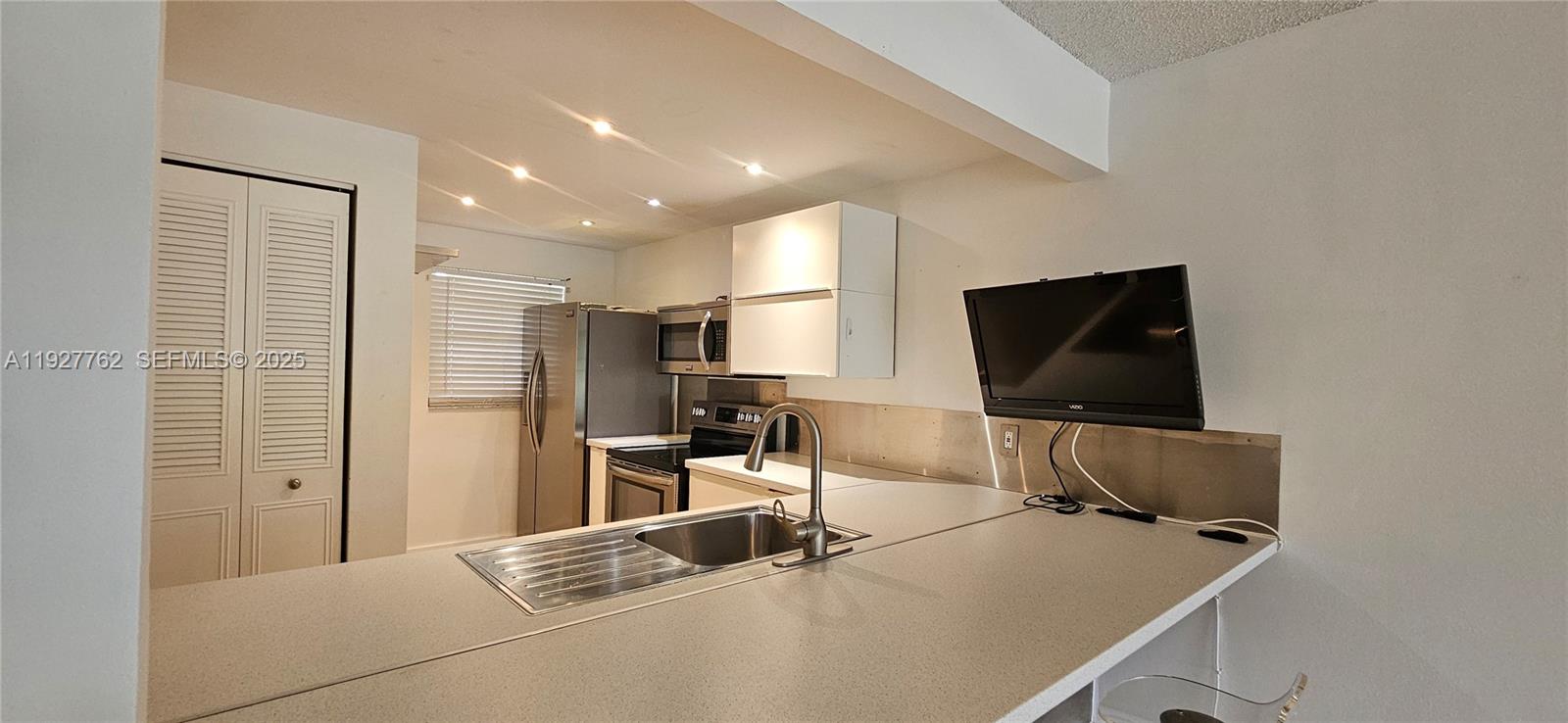 9450 Poinciana Place, Unit 103 Davie, FL 33324 - Photo 22 of 30 a room with a flat screen tv and chairs