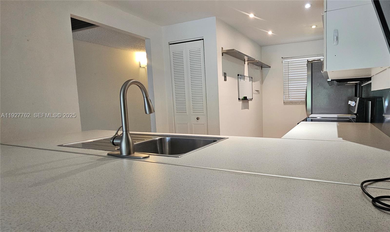 9450 Poinciana Place, Unit 103 Davie, FL 33324 - Photo 23 of 30 a kitchen with a refrigerator and a sink