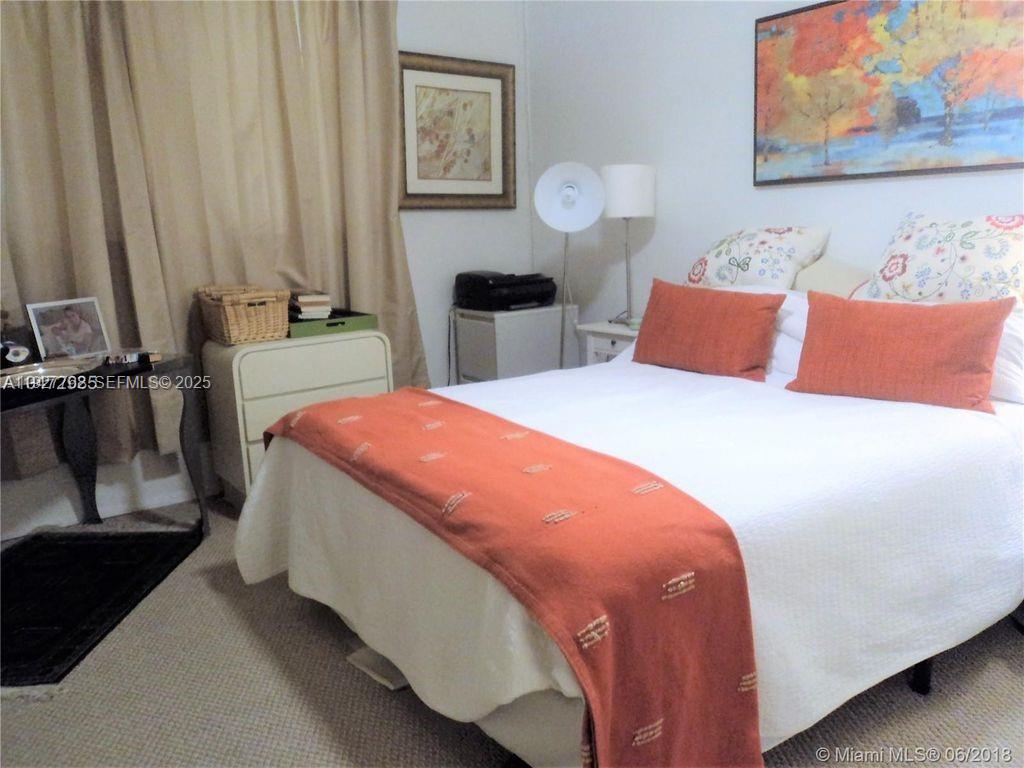 9450 Poinciana Place, Unit 103 Davie, FL 33324 - Photo 26 of 30 a bedroom with a bed and wooden floor