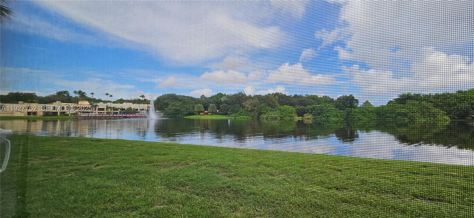 9450 Poinciana Place, Unit 103 Davie, FL 33324 - Photo 28 of 30 a view of a lake with houses in the back