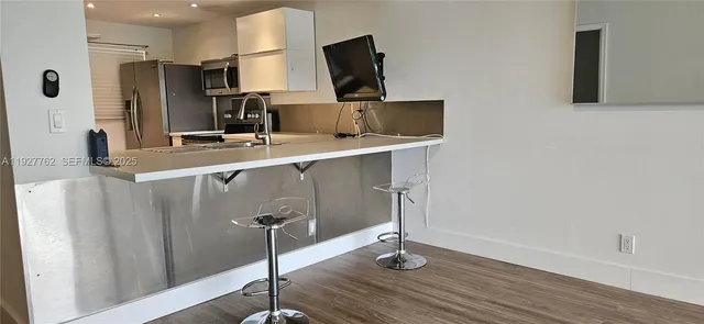 a kitchen with stainless steel appliances a sink and a refrigerator