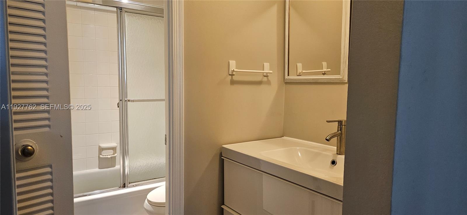 9450 Poinciana Place, Unit 103 Davie, FL 33324 - Photo 8 of 30 a bathroom with a sink and mirror