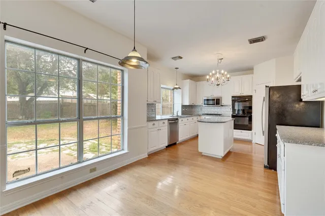 a view of a kitchen with a sink and refrigerator
