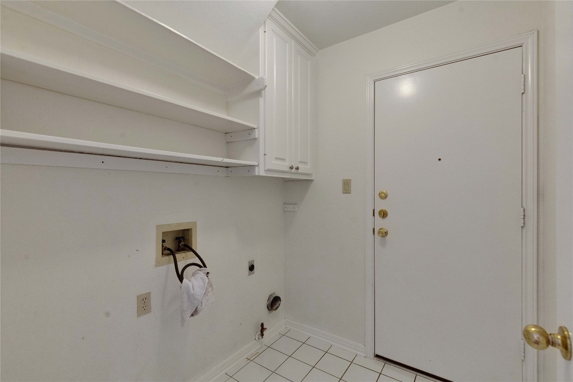 5407 Merrywing Circle Austin, TX 78730 - Photo 18 of 36 Laundry room featuring light tile patterned floors, washer hookup, hookup for a gas dryer, hookup for an electric dryer, and cabinet space