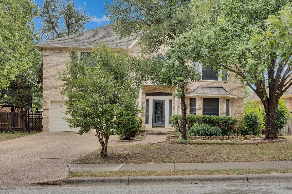 5407 Merrywing Circle Austin, TX 78730 - Photo 2 of 36 View of front facade featuring brick siding, driveway, roof with shingles, and a garage