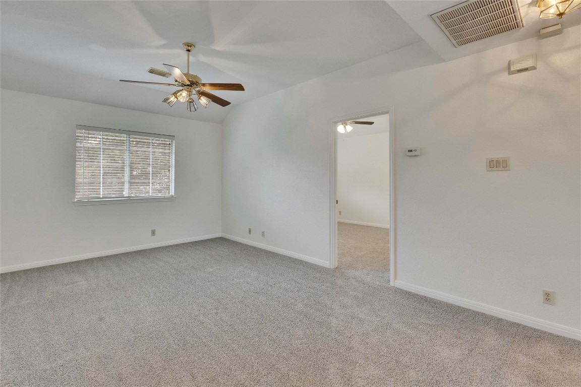 5407 Merrywing Circle Austin, TX 78730 - Photo 21 of 36 Empty room featuring vaulted ceiling, light colored carpet, and a ceiling fan