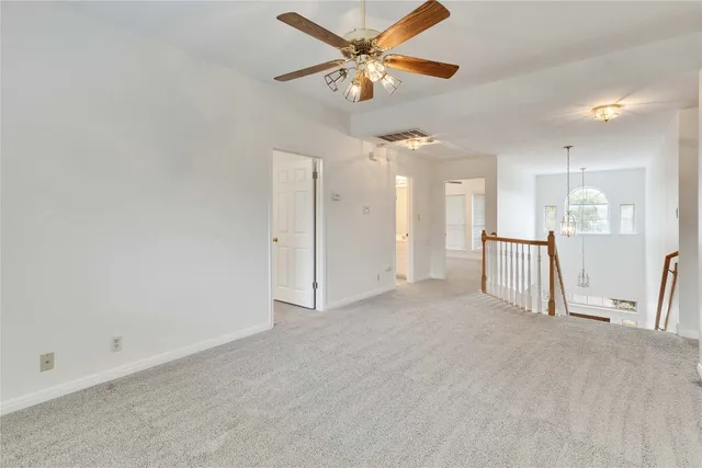 an empty room with a ceiling fan and a window