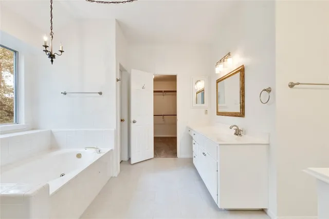 a bathroom with a tub sink and mirror