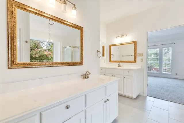 a bathroom with a double vanity sink window and mirror
