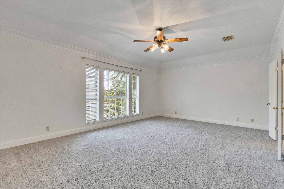 5407 Merrywing Circle Austin, TX 78730 - Photo 34 of 36 Empty room featuring light carpet, a ceiling fan, and ornamental molding